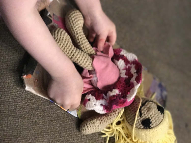 Image is the same from the Pinterest collage shown at the top of the post. In this Ada is closing the diaper using the Velcro while the doll smiles up at her on the changing pad. 