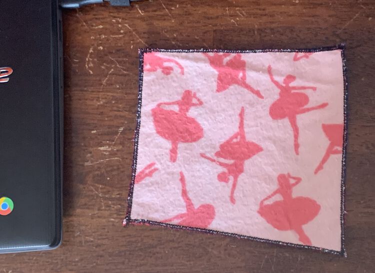 Image shows a slightly off square-ish coaster with fuzzy pink ballerinas on a light pink background. The edge is lined in black.