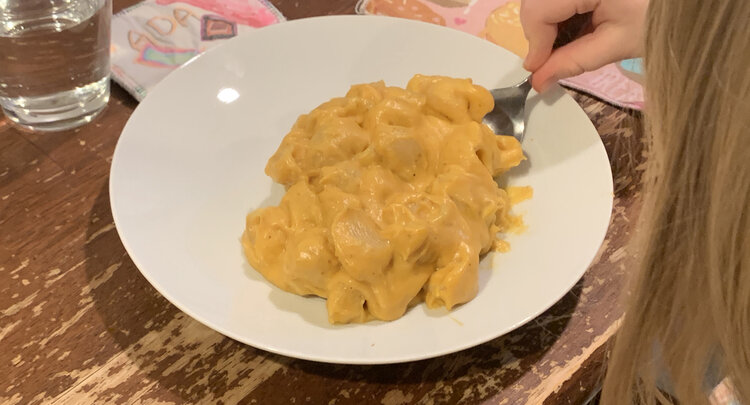 Image shows the side of Ada's head while she takes her first spoonful of the pasta. 