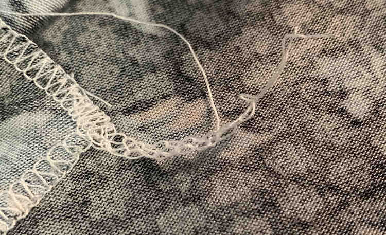 Image shows the same thread tail as before but this time it's half as short. There are three threads coming from the end of the tail.