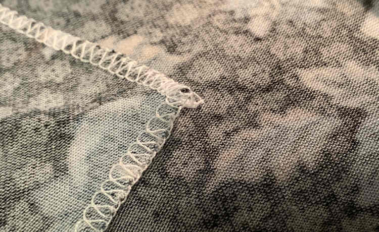 Image shows the same corner of fabric but this time there is only a slight knot and no thread tail as it was trimmed too short.