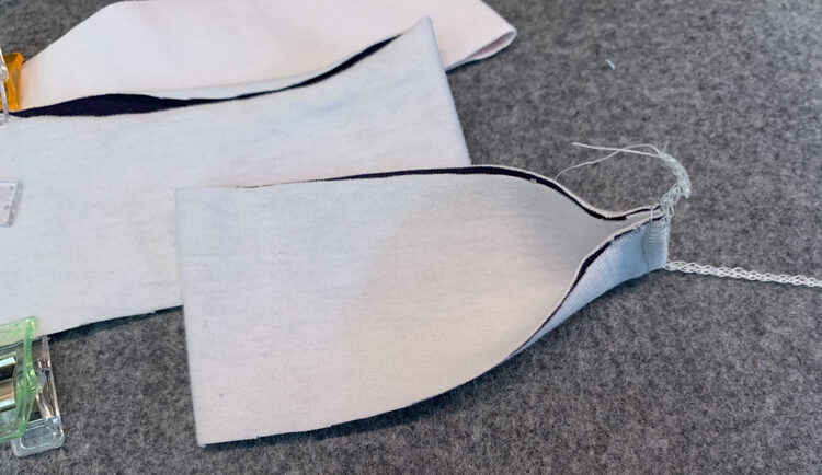 Image shows the serged sleeve cuff as the un-serged end is unfolded. 