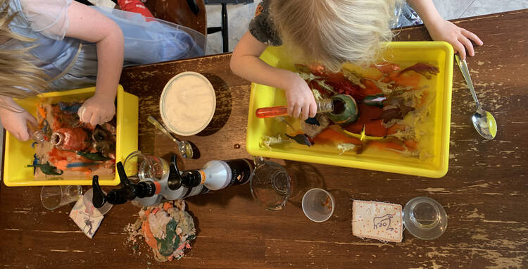 Image taken from above looking at the kids playing in their volcano sensory bin. 