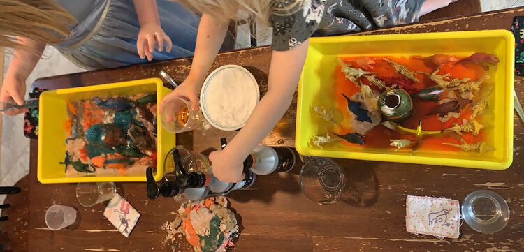 The last bit of bubbly blue lava comes out of Ada's volcano as Zoey works the colored vinegar.