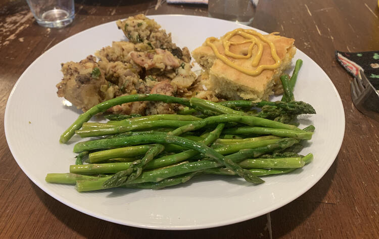 Image shows a white with mustard swirled cornbread, the potato dish, and a pile of bright green asparagus.  