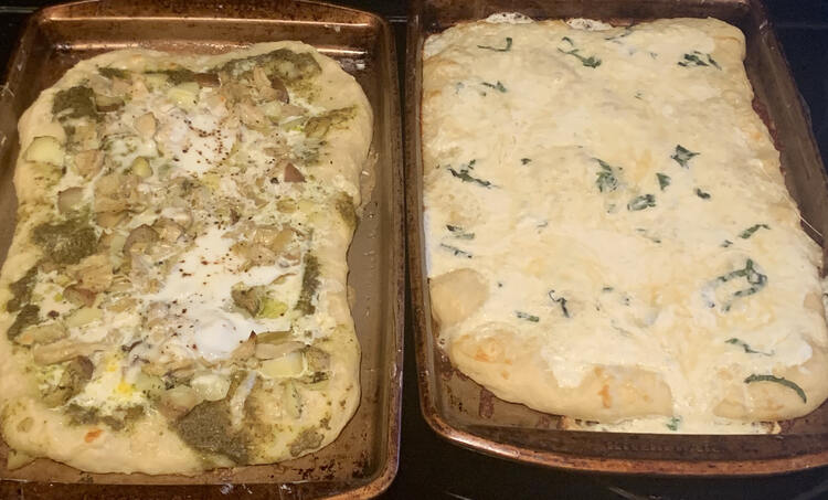 Same image as before with the two pizzas side by side but now they're all cheese melty or egg cooked fresh from the oven. 