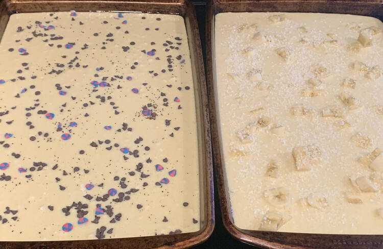 Image shows both of the two previous cookie sheets side by side. The left one is sprinkled with brown, pink, and blue while the right one is more bland with matching bananas and white coconut flakes. 