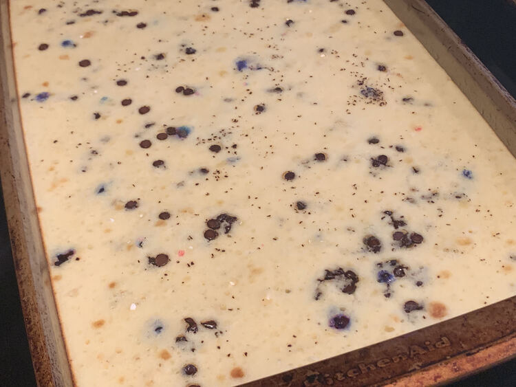 Image shows a closeup of a sheet of pancakes with brown slots of varying sizes (chocolate_ and the odd spot of purple where the unicorn chips show through from the bottom of the pan. 
