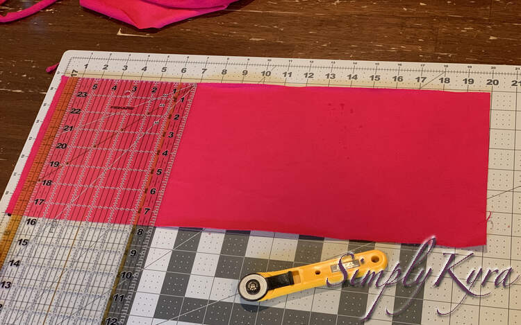 Image shows a large rectangle of pink fabric with the clear quilting ruler laid out showing it is 7.75 inches tall. 