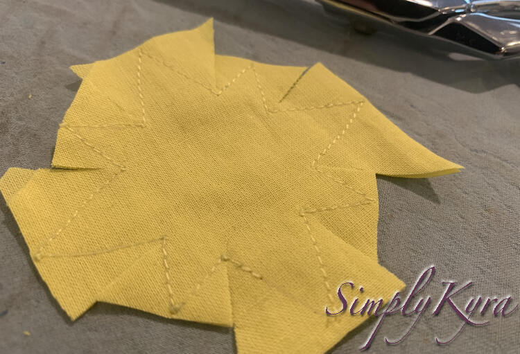 Image shows the yellow fabric with the excess fabric around the star cut off. 