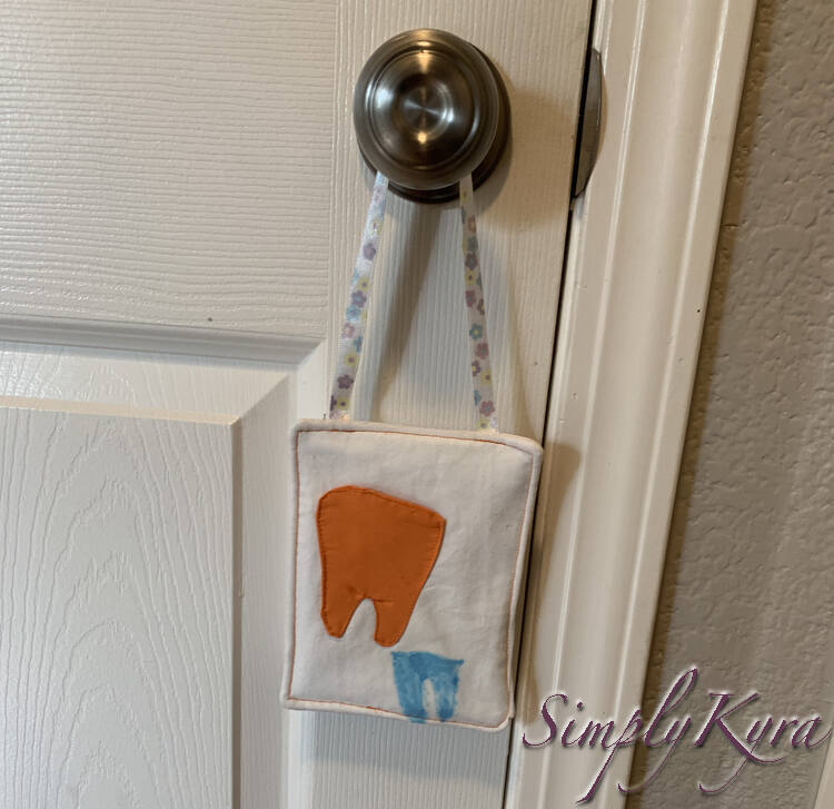 Image of Zoey's orange tooth hanging.