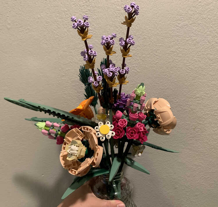 Same close photo of the bouquet against the wall as the previous one but this time it's turned at a different angle to see more of the pink and purples. 