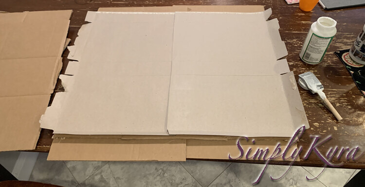 Image shows the lightened cardboard square with the two cereal boxes glued down side by side and slightly overlapping. 