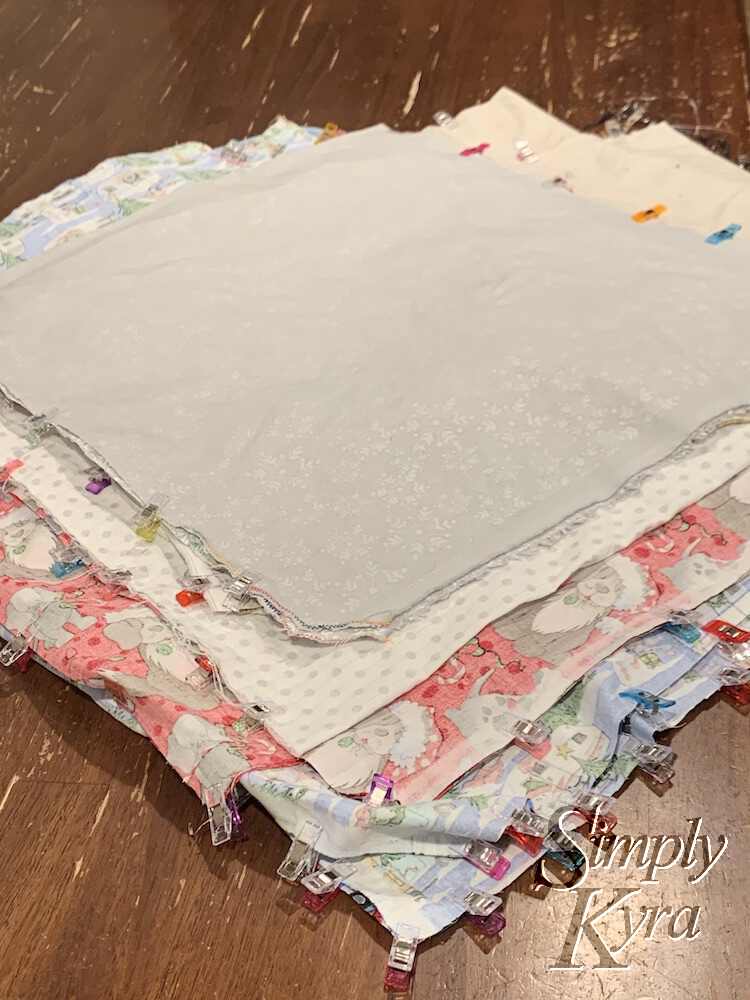 Pile of all the cut remnants with their top corners finished and their openings (both sides on some and a single side and bottom on others) clipped closed to sew. 