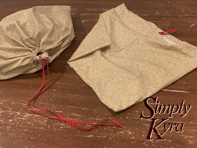 Image shows the same two bags from before but now the one on the right is flat with only a bit of trim sticking out while the one on the left is cinched close with lots of trim trailing on the table.