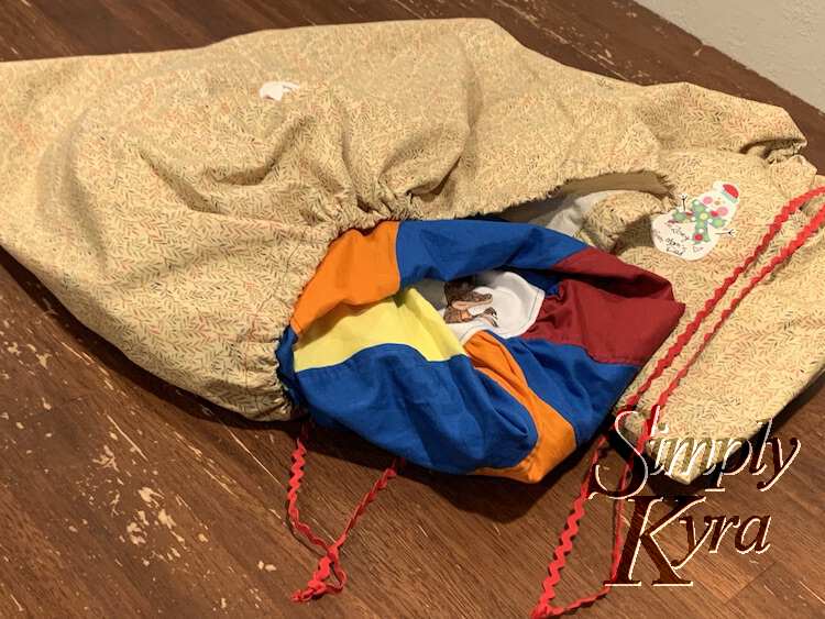 Image shows the yellow leafed bags laid out on the table. The one on the right is cinched close and the one on the left has a dress sticking out. 