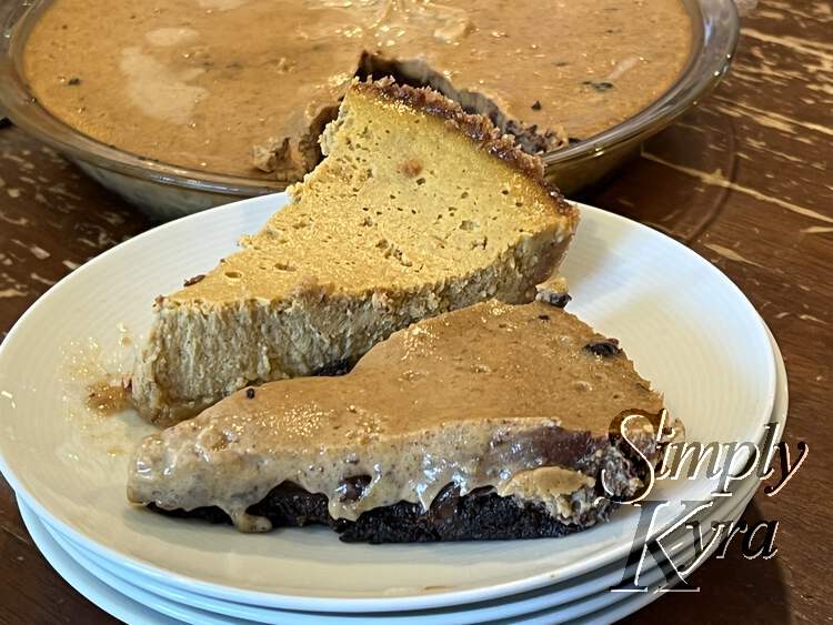 Image shows both pie pieces placed side by side on a pile of white saucers in front of the large pie. 