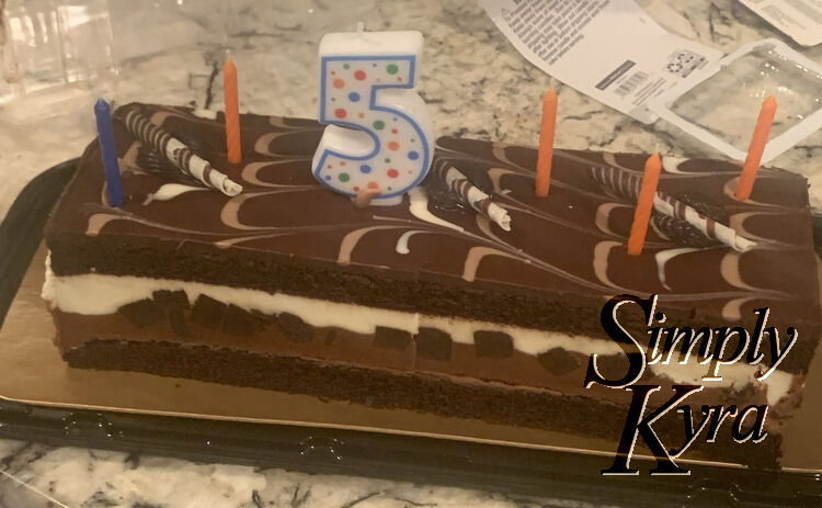 Image shows a grocery store cake festooned with birthday candles. 