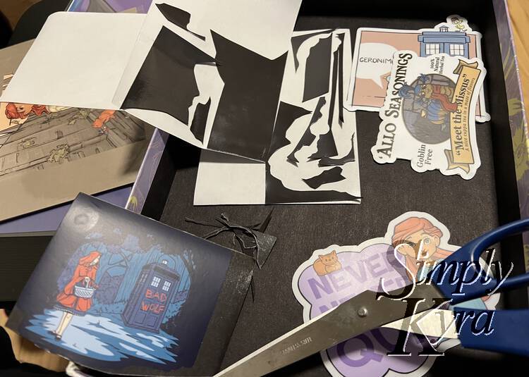 Image shows all four magnets with the magnetic sheet backing off to the side coated in excess little bits. Two magnets are trimmed completely, one partially with the scissors overtop, and one final one is waiting to be trimmed.