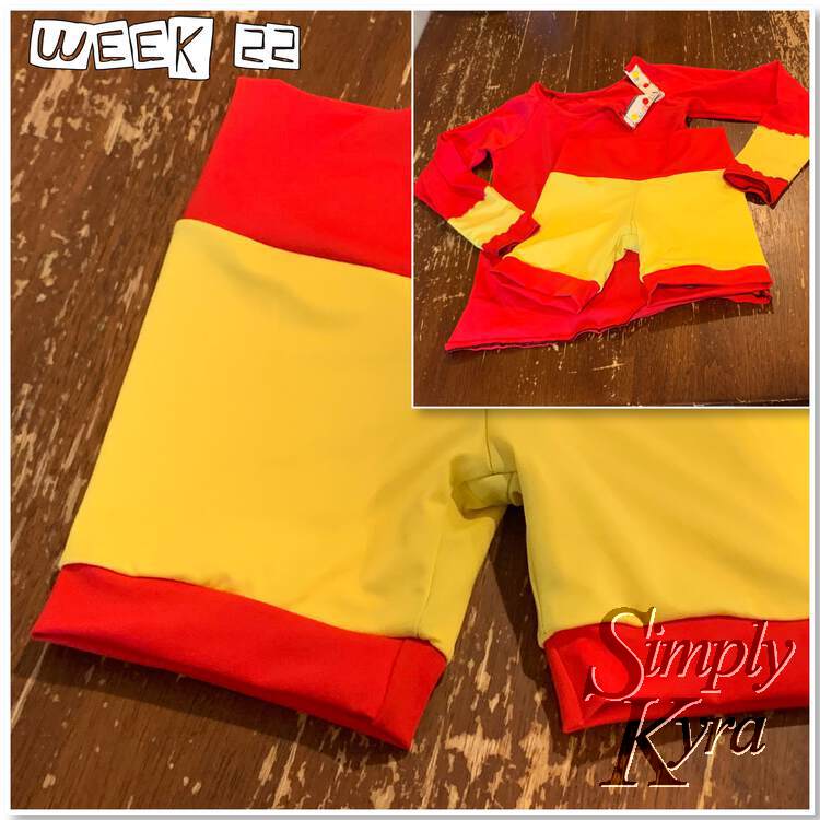 Image shows a small image, top right, superimposed over a larger photo. The words "week 22" are along the top left. The large photo shows the red banded yellow swim shorts I sewed up. The smaller image shows the same shorts laid out over last year's top.  
