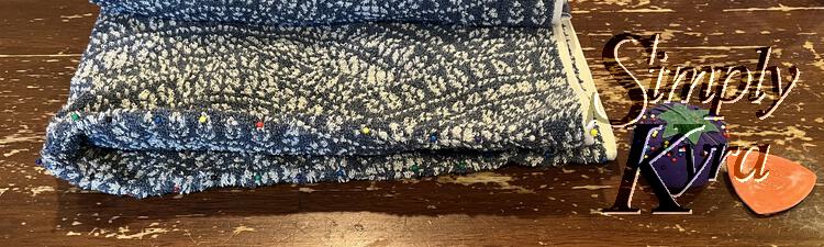 Image shows the folded towel with small dots of color along the folded edge showing where the sewing pins were inserted and thus where the center of the towel is.