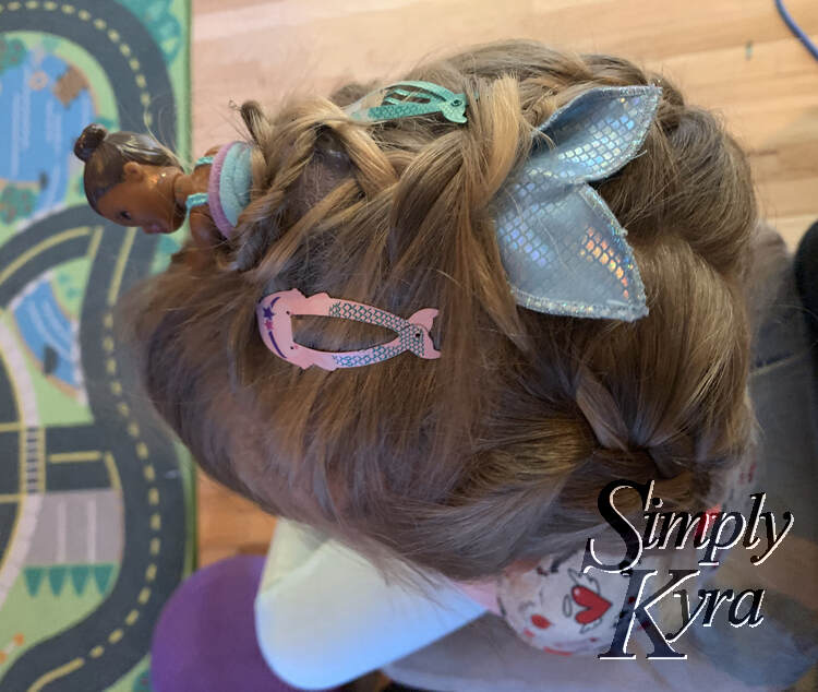 Image is once again taken from above but this time a bit more to the side. You can see the part at the back of Ada's head and the hair French braided on the way down.