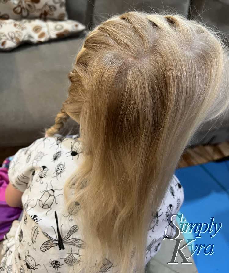 Image is taken from above and to the side so Zoey's loose hair is towards the camera as she looks to the right. You can see the zigzag and the braid on the backside. 