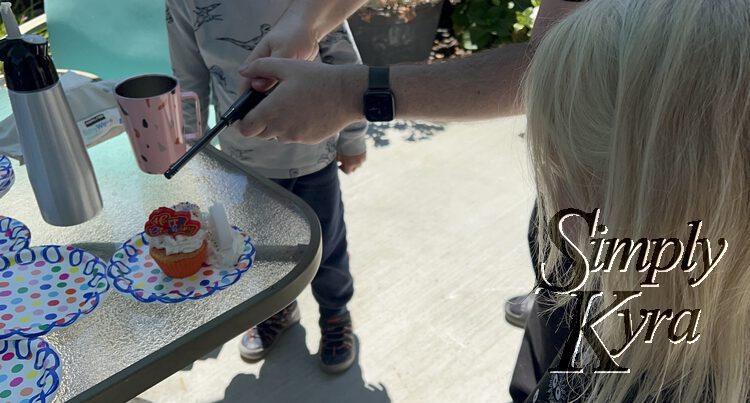 Image shows Matt lighting up the candles on the cupcake while Zoey watches. 