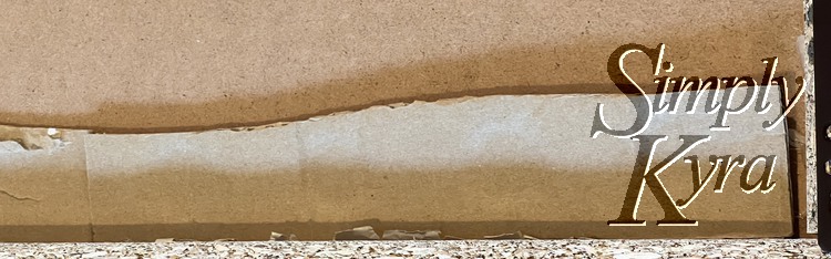 Image shows one side of the same drawer with another piece of cardboard touching the first one's edge and stretching almost to the edge of the drawer.