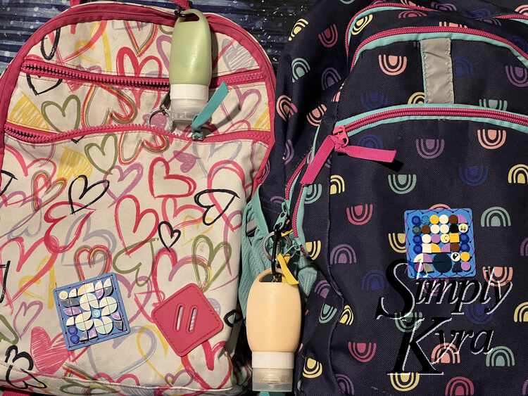 Image shows the backpacks side by side with the sunscreen tube and toys visible.