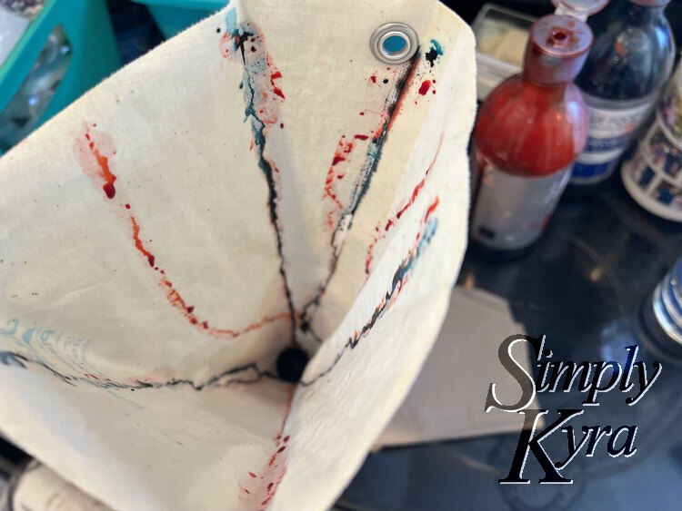 Image shows the top of the bag with streaks of red and blue going to the top (and out the bottom onto the napkin). The blue streaks are overlapping with the red ones in the hope to make purple.