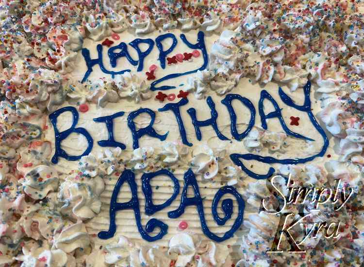 Closeup of the words not eh cake with the small X and O sprinkles around it and surrounded by the swirled flowers and sugar sprinkles. 