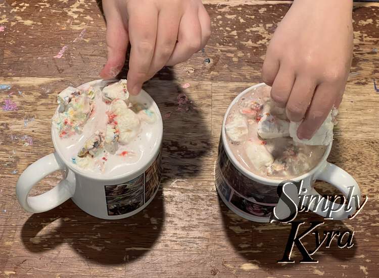 Image is taken from above and to the front while they place whip cream in their mugs.