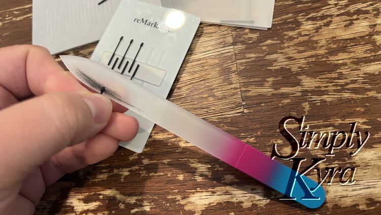Image shows me filing the edge of the black pen tip against a white glass nail file. You can see the residue where I've previously used it.