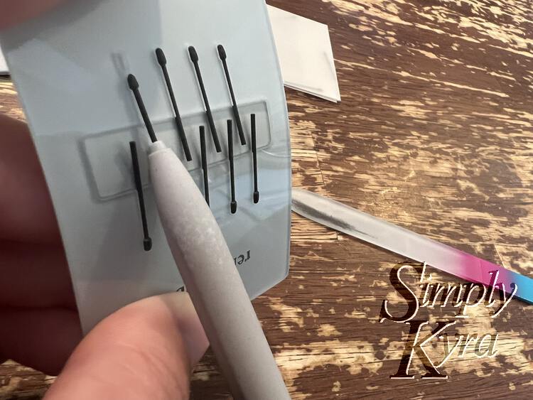 Image shows the card upside down and bent so the tips ends are facing out making it easier for the pen to slide onto one of them. 