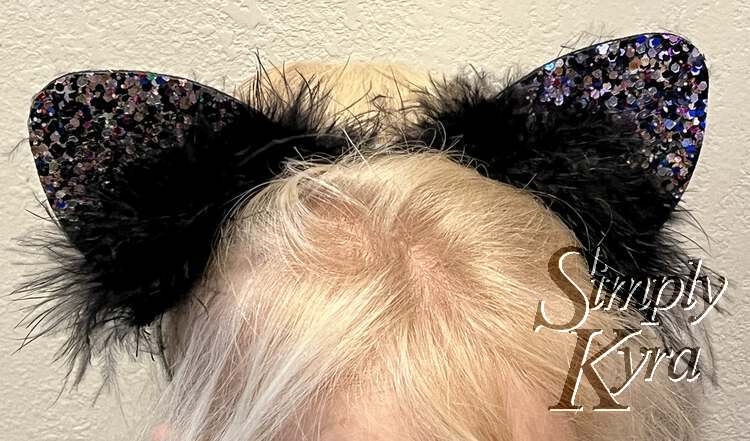Image is a close up of Zoey's head showing the furry and glitter encrusted black ears.