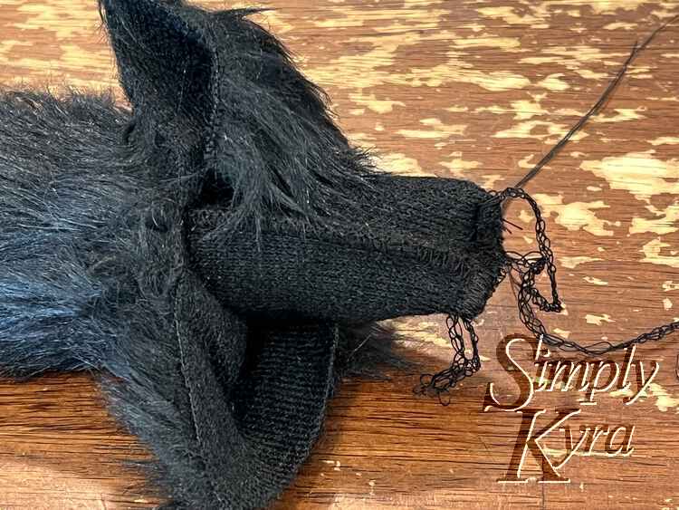 Image shows the tail partially turned right side out but with the tail tip sticking out and sewn closed. 
