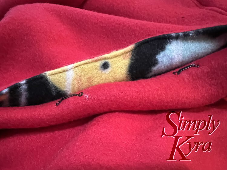 image shows the jacket closed with the eye on the one side and the marked spot on the other for the hooks.