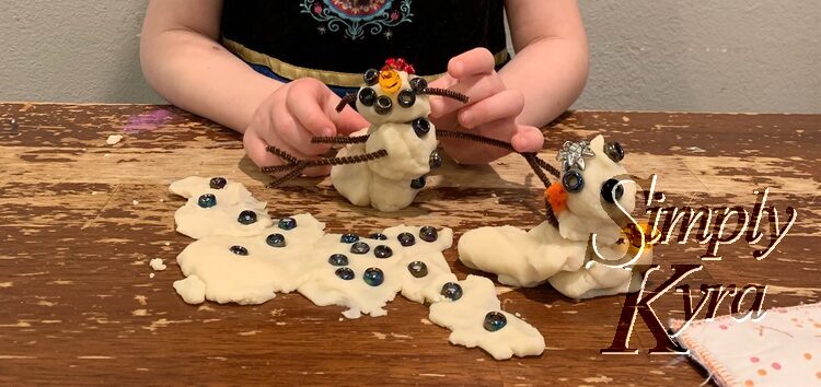 Closeup of Zoey's version of snow people. There's also a puddle of play dough between the snow people with the beads pressed in. 